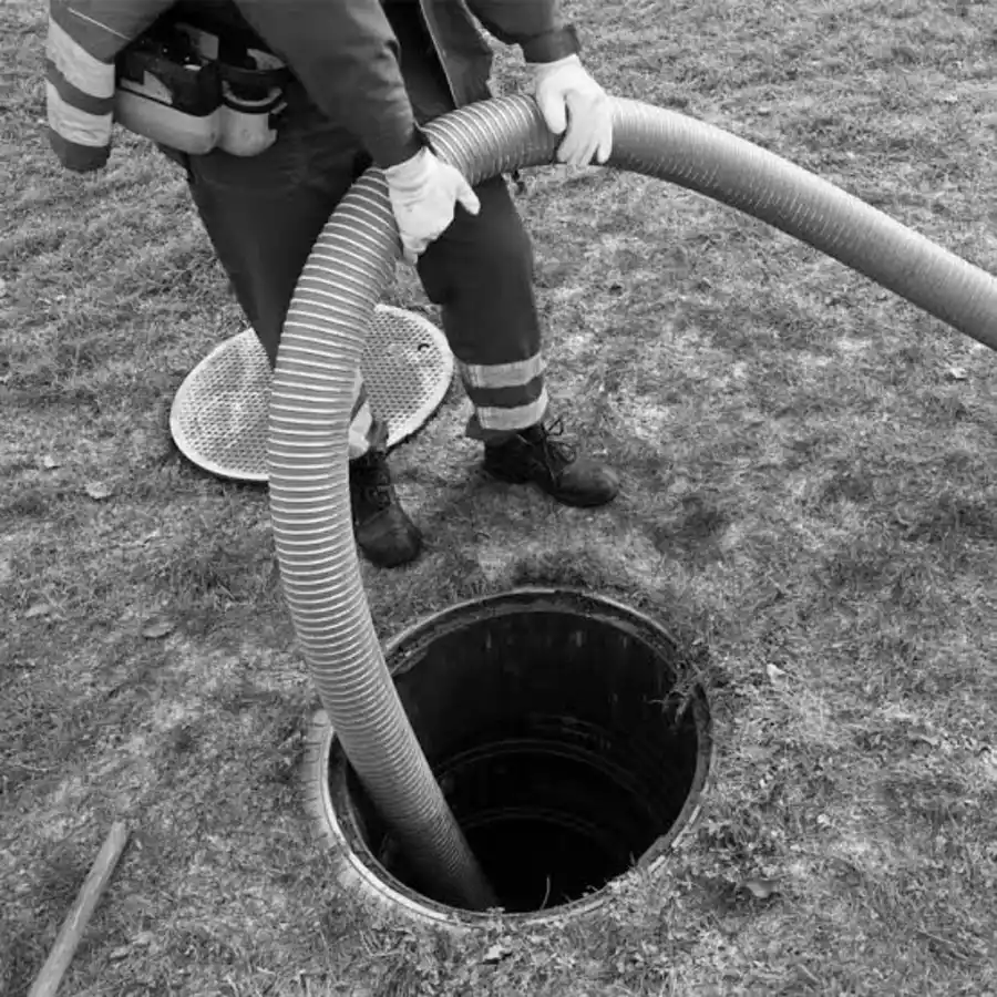 Commercial and HOA septic pumping - technician pumping a tank through the access riser
